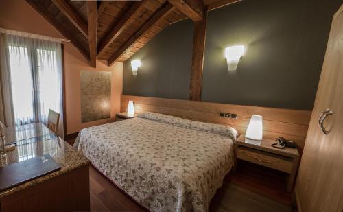 a bedroom with a bed and two lamps and a window at Adeko Hotel in Barakaldo