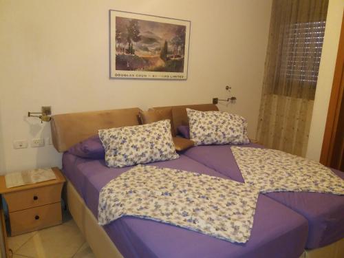 Un dormitorio con una cama con sábanas y almohadas púrpuras. en Holiday Apartments Eilat, en Eilat