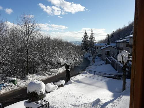 a view of a snow covered street with trees and buildings at B&B La Tana Dei Ricci in Sestola