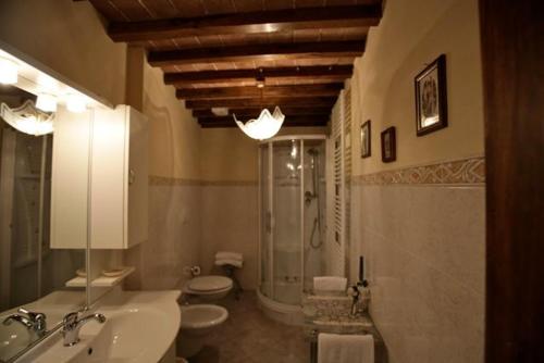 een badkamer met 2 toiletten, een wastafel en een douche bij Dolce Maria in Cortona