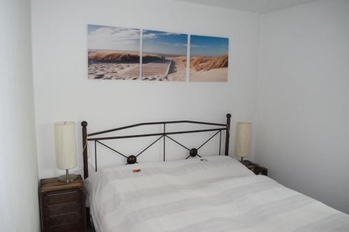 1 dormitorio con 1 cama con 3 cuadros en la pared en Tango Ferienwohnung Winnenden, en Winnenden