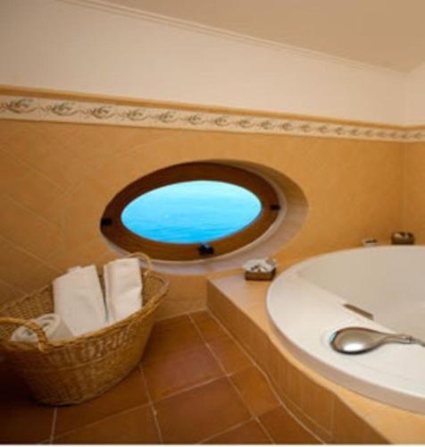a bathroom with a sink and a round window at Villa Ketty Resort in Vico Equense