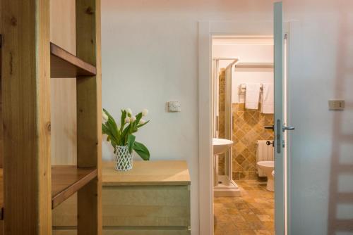 een badkamer met een toilet en een vaas met bloemen bij Casa Raffaella in Pisa