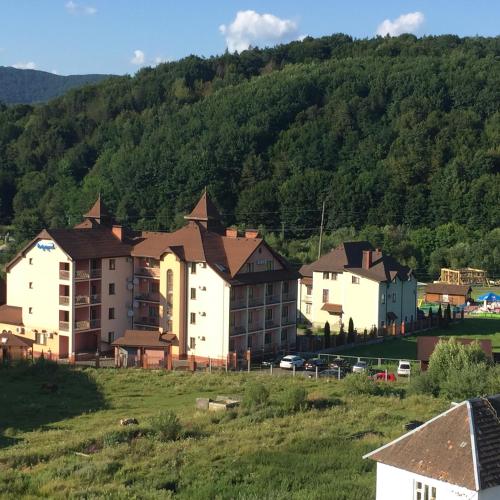 a group of buildings in front of a mountain at Polyana Apart in Polyana
