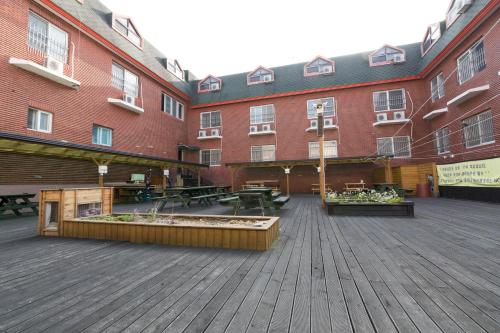 a large building with benches and tables in a courtyard at Seorak HOT Spring Mammoth Resotel in Sokcho