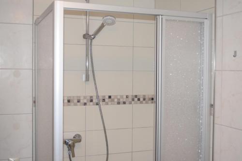 y baño con ducha con cabezal de ducha. en Tango Ferienwohnung Winnenden, en Winnenden