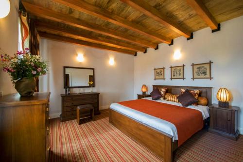 a bedroom with a bed and a dresser and a mirror at Cheltenham Cottage - Little England Cottages in Nuwara Eliya