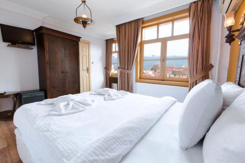 a bedroom with a large white bed with a window at Cheers Vintage Hostel in Istanbul