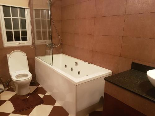 a bathroom with a tub and a toilet and a sink at Cheltenham Cottage - Little England Cottages in Nuwara Eliya