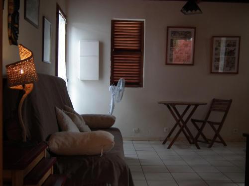 a living room with a couch and a table at Le Cardinal des Grands Bleus in Saint-Leu