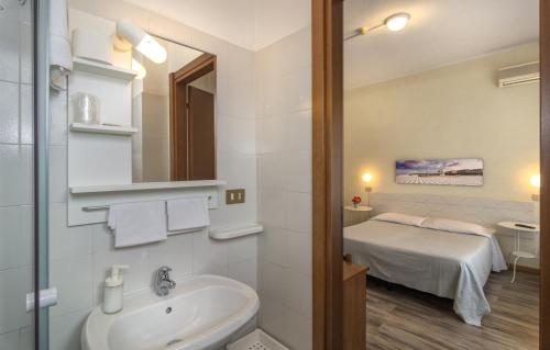 a bathroom with a sink and a bed in a room at Hotel Cecile in Pisa