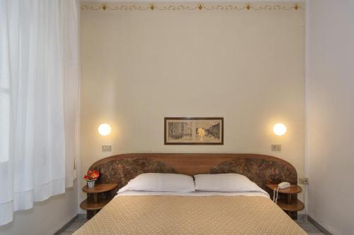 a bedroom with a bed with two pillows on it at Hotel Cecile in Pisa