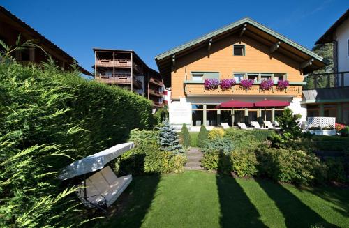 a house with a balcony with flowers on it at NaturResidence Dolomitenhof in Siusi