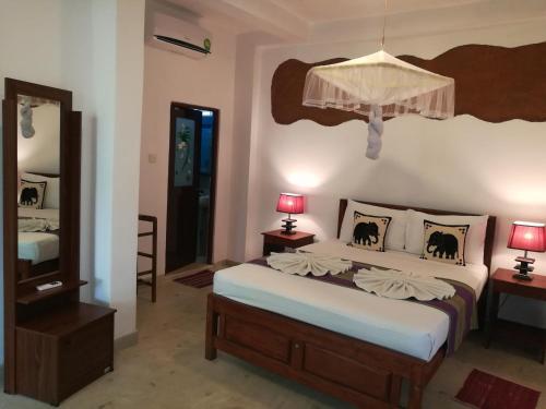 a bedroom with a bed and a lamp at The Nature Park Villa in Sigiriya