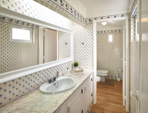 ein Badezimmer mit Waschbecken und Spiegel in der Unterkunft E&M Beach House Aldeamento do Levante I in Armação de Pêra