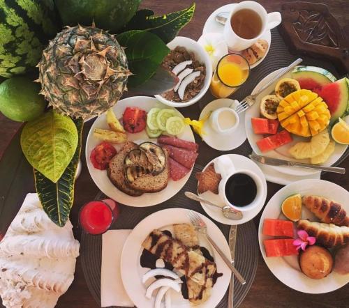 una mesa con platos de comida y tazas de café en Villa Kiva Boutique Hotel, en Matemwe