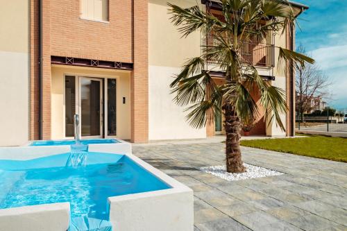 Stabiuzzo的住宿－Cimadolmo Prosecco And History，一座带游泳池的建筑前的棕榈树