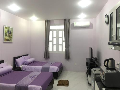 a bedroom with two beds and a tv in it at HT Hotel Apartment in Ho Chi Minh City