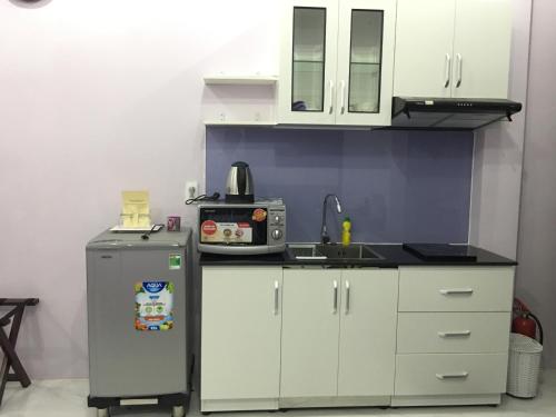 a small kitchen with a refrigerator and a sink at HT Hotel Apartment in Ho Chi Minh City