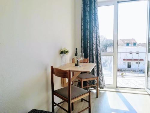 Apartment Ivana في درفينيك: طاولة وكراسي في غرفة مع نافذة
