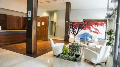 an office lobby with white chairs and a table at Gran Hotel Albacete in Albacete