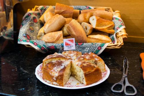a table with a plate of bread and a basket of breadsticks at Hotel KLE, BW Signature Collection in Kaysersberg