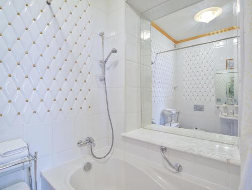 a bathroom with a shower and a tub and a sink at La Gioconda Boutique Hotel in Odesa