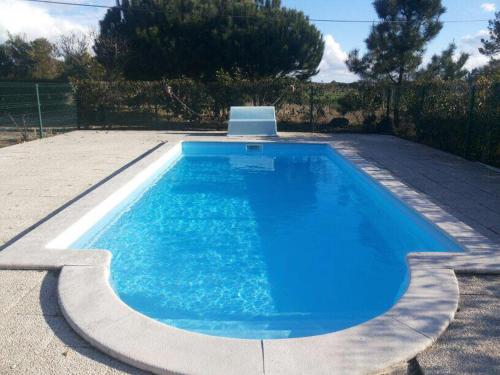 una gran piscina azul en un patio en Casa da Samouqueira, en Rogil