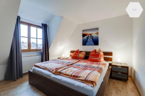 - une chambre avec un grand lit et des oreillers orange dans l'établissement Apartment 81 qm, Messe/Exhibition Center, à Nuremberg