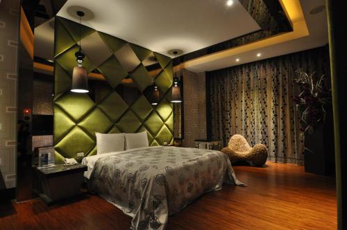 1 dormitorio con 1 cama con pared verde en Qixing Jingpin Motel, en Ho-mei