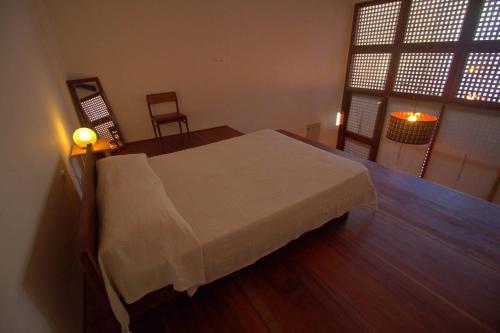 a bedroom with a bed and a table and a window at Studio M in Mindelo