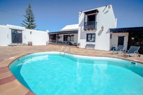 una gran piscina frente a una casa en casa los veroles lanzarote en El Islote