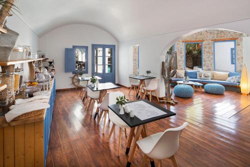 - un salon avec des tables, des chaises et un canapé dans l'établissement Meltemi Suites, à Perissa
