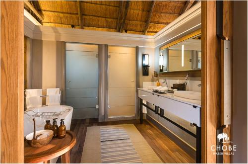 La salle de bains est pourvue de 2 lavabos et d'un miroir. dans l'établissement Chobe Water Villas, à Kasika