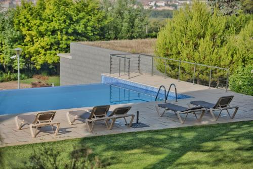 a patio with chairs and a swimming pool at Mas Ses Vinyes - Adults Only in Begur