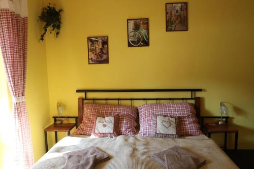 1 dormitorio con 1 cama con 4 cuadros en la pared en Apartmán Beta Podhájska, en Podhájska