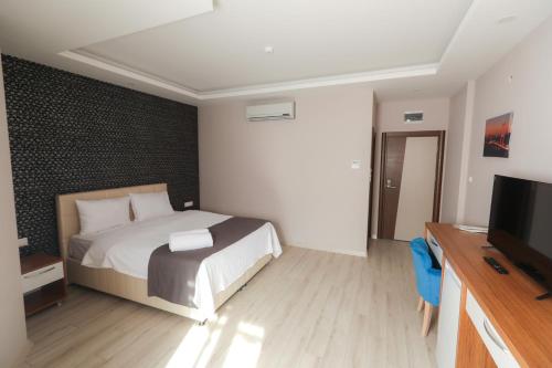 a bedroom with a bed and a flat screen tv at Grand Dost Hotel in Osmancık