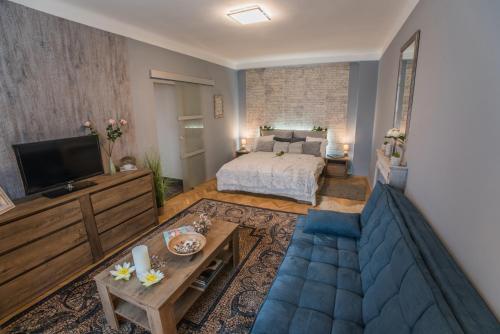 ein Wohnzimmer mit einem Bett und einem blauen Sofa in der Unterkunft Jewellery box on the riverside in Budapest
