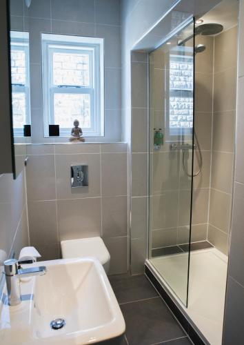 y baño con ducha y lavamanos. en The Green House classic 2 bedroom apartment, en Harrogate