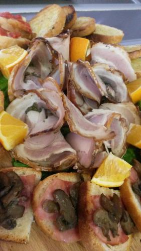 a plate of food with meat and mushrooms on bread at Hotel Cluentum in Tolentino