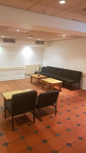 a room with a couch and a table and chairs at Leinster House (Bayswater) in London