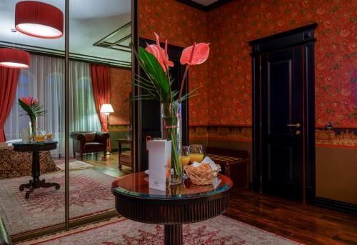 a room with a table with a vase of flowers on it at La Gioconda Boutique Hotel in Odesa