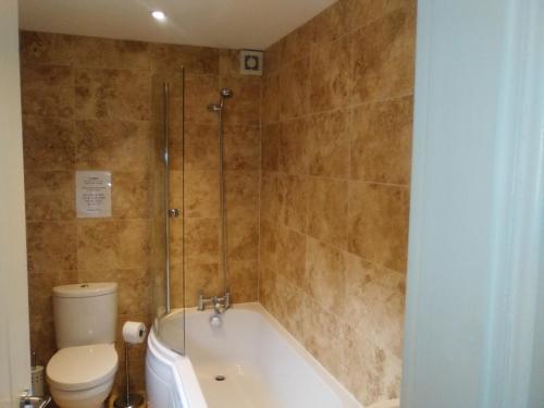 ein Bad mit einer Badewanne, einem WC und einer Dusche in der Unterkunft Waterside Cottage in York