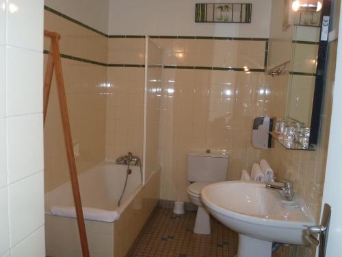 een badkamer met een bad, een toilet en een wastafel bij Hôtel La Résidence in Villeneuve-sur-Lot