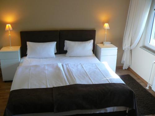 a bedroom with a large bed with two night stands at Waldhotel "Peter aufm Berge" in Bielefeld