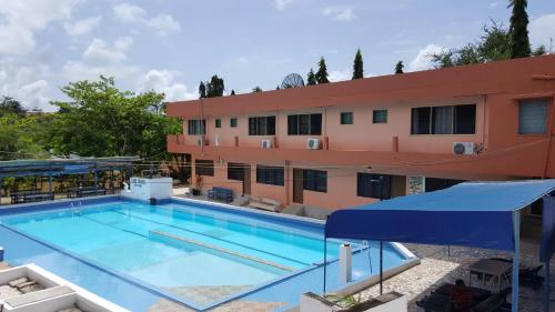 a large swimming pool in front of a building at Hans Cottage Botel in Cape Coast