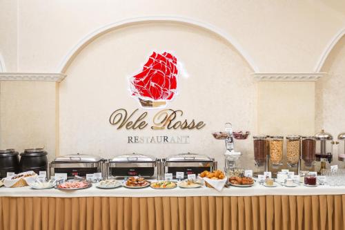 a table with plates of food on it at Vele Rosse Hotel, business & leisure in Odesa