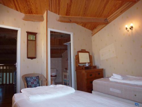 een slaapkamer met 2 bedden, een dressoir en een spiegel bij Comfortable Gite (2) in attractive Languedoc Village in Magalas