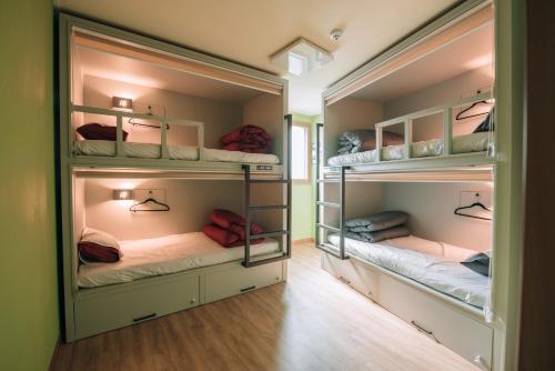 two bunk beds in a room with wood floors at Daegu Midtown Hostel in Daegu