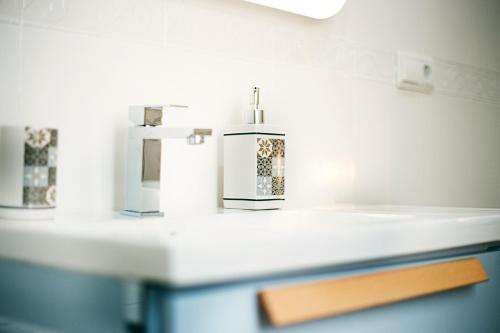 un lavandino da bagno con 2 dispenser di sapone su un bancone di HI Suite Málaga Centro a Málaga